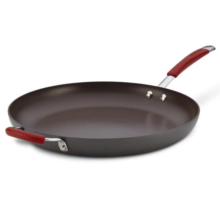 The 14-Inch Cucina Hard Anodized Nonstick Frying Pan with red handles, including a helper handle, is displayed against a white backdrop, highlighting its sleek design. This hard anodized frying pan is oven safe, catering to versatile cooking needs.
