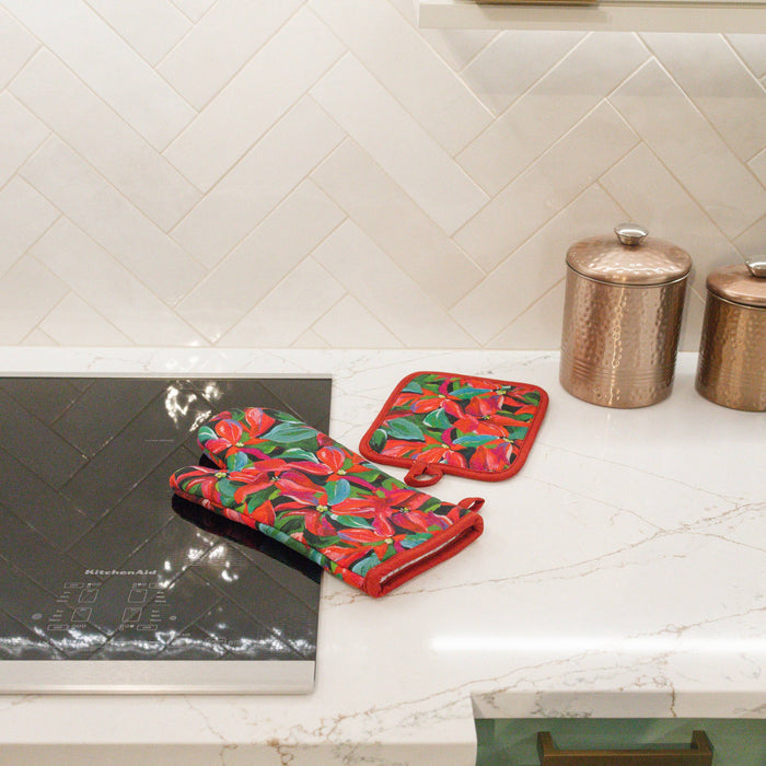 Oven mitt and pot holder in poinsettia pattern on a kitchen counter