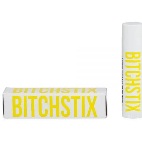 A picture showing two views of a Bitchstix organic lip balm. The first view is the lip balm twisted up, and the second view is the lip balm in a box with the brand name 'Bitchstix' displayed.