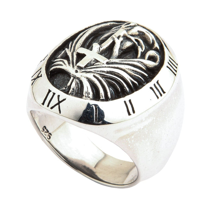 A shot of the Roman numeral ring, detailing the oxidized carving of the cross, hands, and wings.