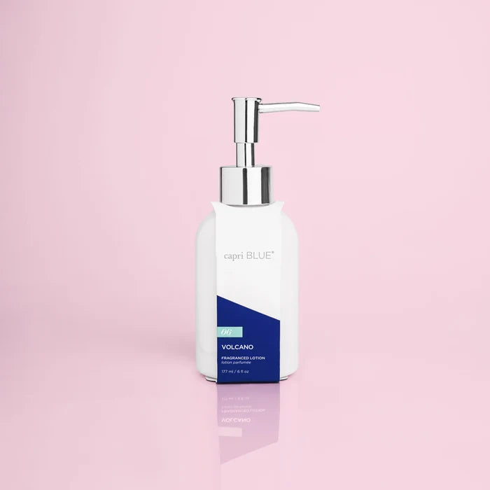 A pump bottle of Curio Capri Blue Volcano fragranced hand lotion on a pink background.