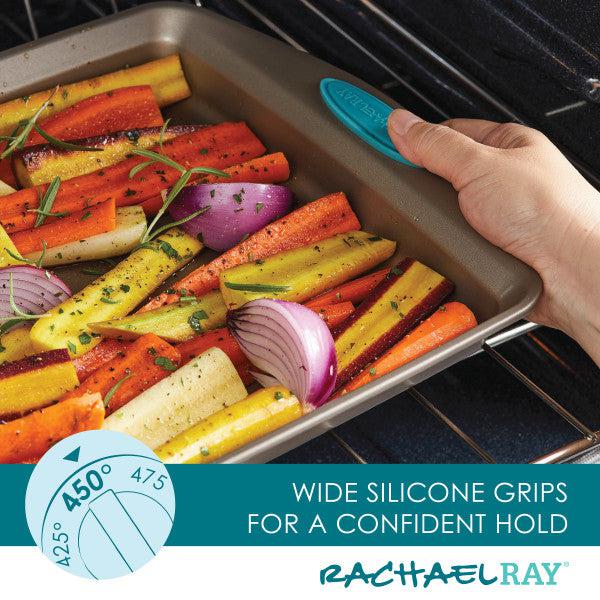Using 2-Piece 9-Inch Nonstick Square Cake Pans, a person carefully places a roasting pan filled with vibrant vegetables into the oven to ensure easy cleanup and perfect roasting every time.