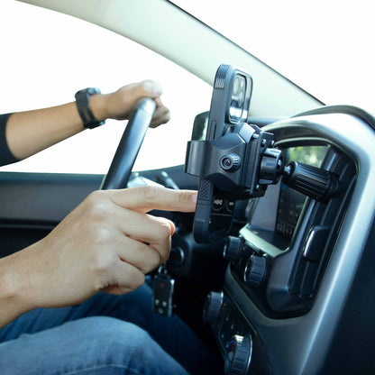 A driver uses their right hand to adjust a smartphone in an Adjustable Car Vent Mount with 17mm Ball on the dashboard, while keeping their left hand on the wheel for safer, hands-free phone use.