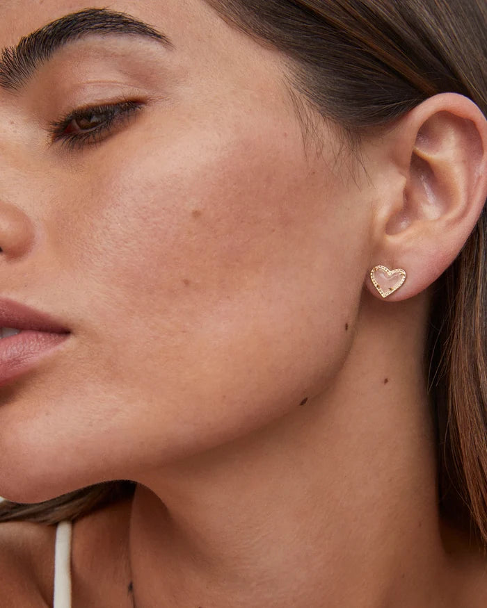 woman wearing heart gold earrings