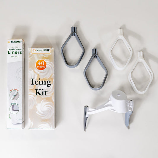 NutriMill bakers bundle including: cookie sheet liners, icing kit, pro line cookie paddles, cake paddles, and bowl scraper on grey background