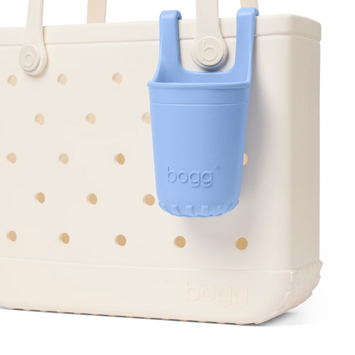 White tote bag with gold polka dots and a blue bogg bag holder on a white background