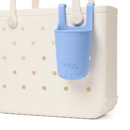 White tote bag with gold polka dots and a blue bogg bag holder on a white background