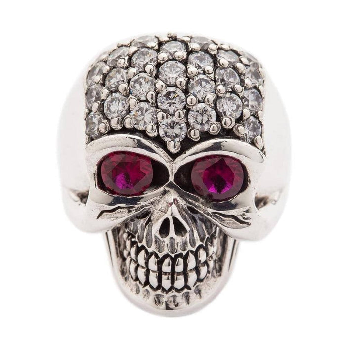 A solid sterling silver bling women's skull ring, featuring a pavé crystal cranium and large, deep red stone eyes.