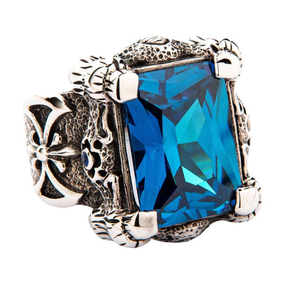 A gothic-style sterling silver dragon claw ring, featuring a rugged, scaly band and a 36-carat blue topaz CZ stone.