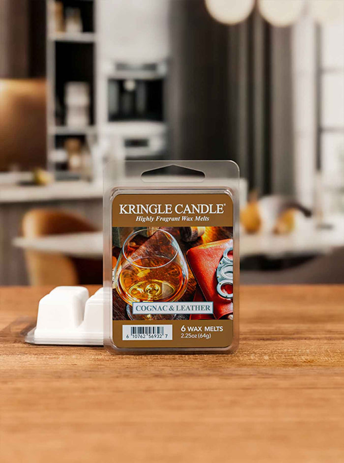 Kringle Candle Cognac & Leather wax melt package on a wooden surface with a blurred background