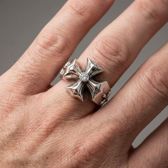 Sterling silver gothic cross ring with center diamond worn on finger, featuring ornate fleur-de-lis style arms and polished finish in close-up product shot
