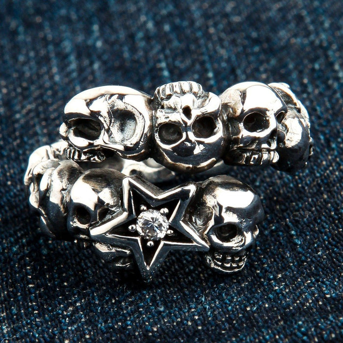 Diamond Star Rock sterling silver ring featuring a band of detailed skulls and a central star set with a clear stone.