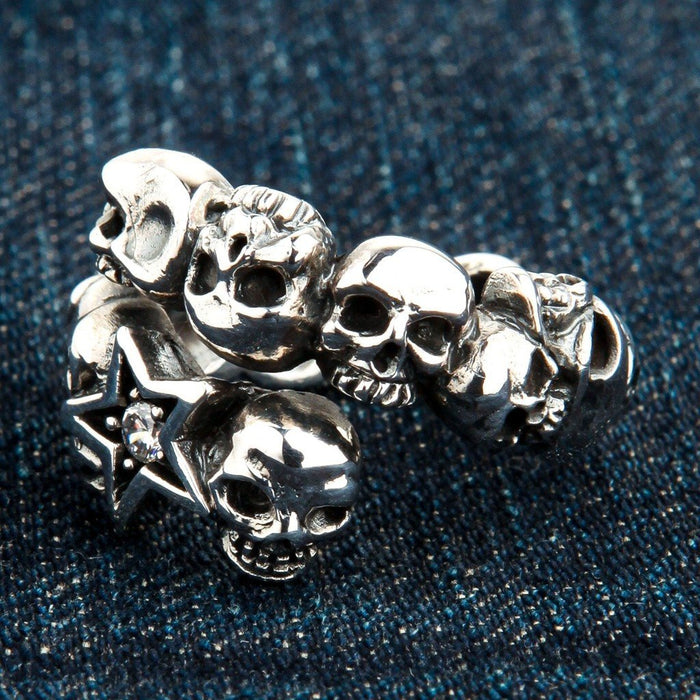 Extreme close-up revealing the textured finish of the carved metal skulls and the faceted clear stone in the star.
