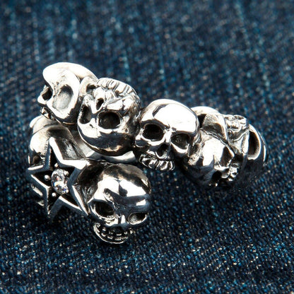 Extreme close-up revealing the textured finish of the carved metal skulls and the faceted clear stone in the star.