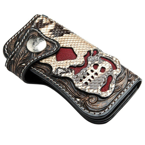 Folded top angle showing the engraved silver snap, carved dark leather, and snake scale skull with red stingray cutouts.
