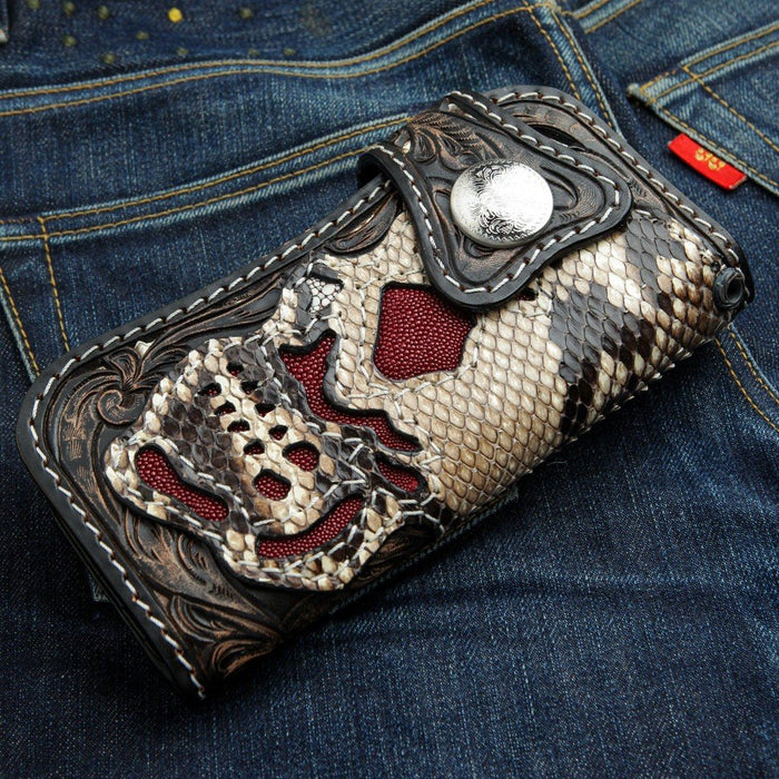 Angled close-up highlighting the snake scale skull cutouts filled with textured red stingray inlay and white stitching.