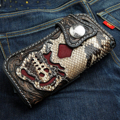 Angled close-up highlighting the snake scale skull cutouts filled with textured red stingray inlay and white stitching.