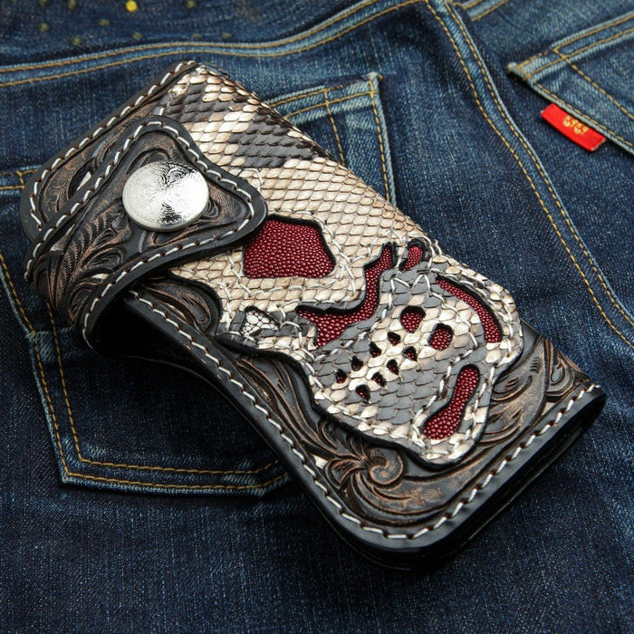 Extreme rider skull biker wallet featuring genuine snake leather scales and red stingray inlay sections resting on blue denim jeans.
