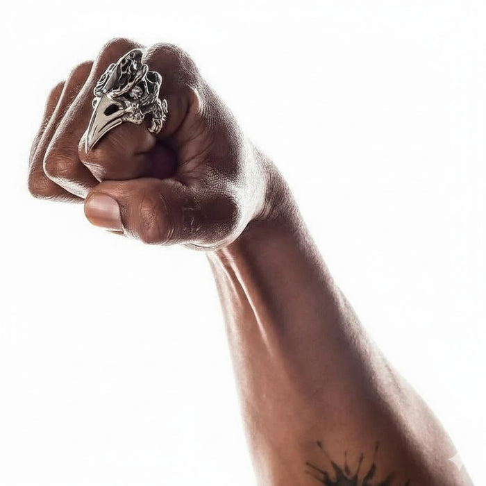A man's hand wearing the large, long fire raven knuckle ring to show its impressive size.
