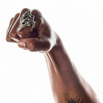 A man's hand wearing the large, long fire raven knuckle ring to show its impressive size.