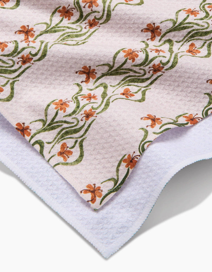 Floral patterned towel with green and orange flowers on a white background
