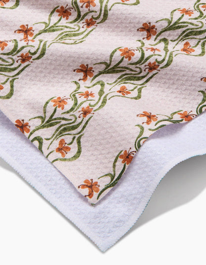 Floral patterned towel with green and orange flowers on a white background