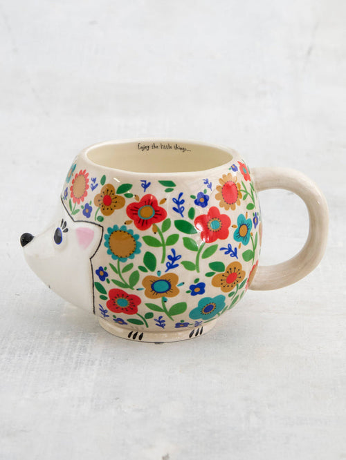Hedgehog-shaped mug with floral design on a white background