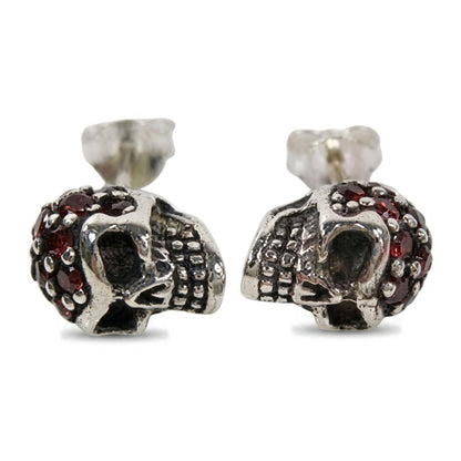 Garnet head skull stud earrings in .925 sterling silver, front pair view with red garnets pavé-set across each crown