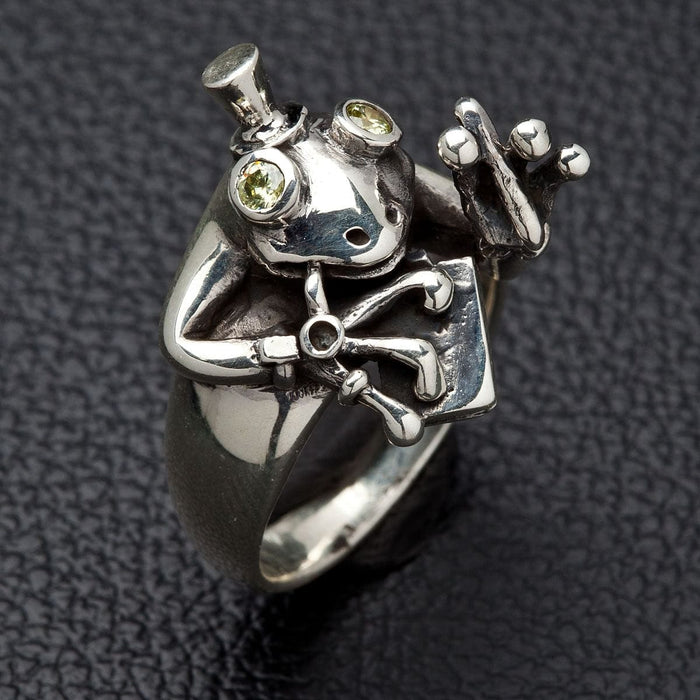 Side view of silver frog ring showing detailed webbed feet and top hat design