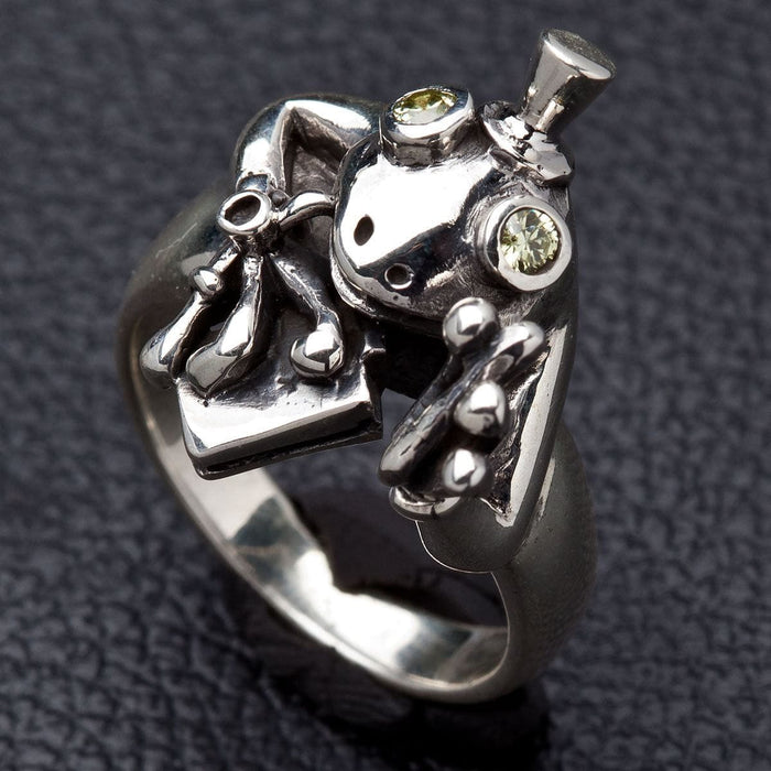 Close up of sparkling light-green stone eyes on silver frog ring
