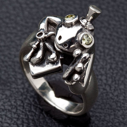 Close up of sparkling light-green stone eyes on silver frog ring