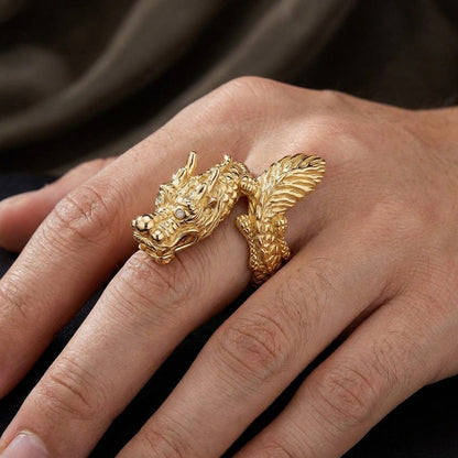 Intricately detailed gold dragon ring with scales and horns featuring diamond eyes worn on a hand, showcasing Asian-inspired sculptural jewelry design with a dramatic wrap-around serpentine body