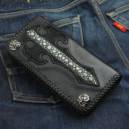 Resting on blue denim, the pebbled leather wallet displays its flush-inlaid stingray cross and braided edges.
