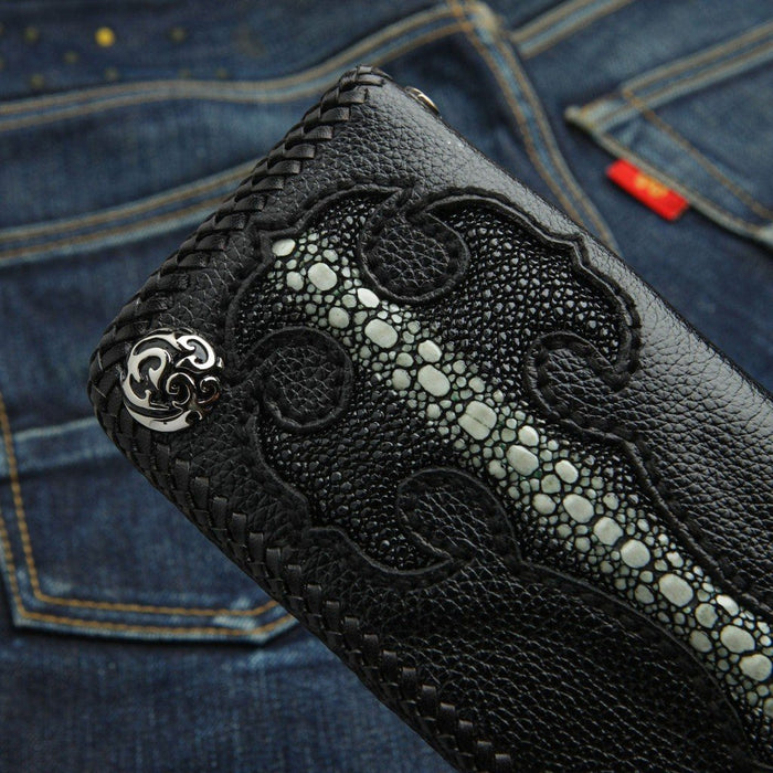 Close-up of the silver concho and flush-inlaid stingray cross on the black pebbled leather wallet against denim.