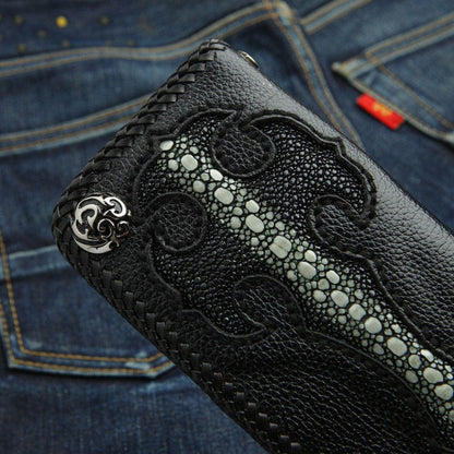 Close-up of the silver concho and flush-inlaid stingray cross on the black pebbled leather wallet against denim.