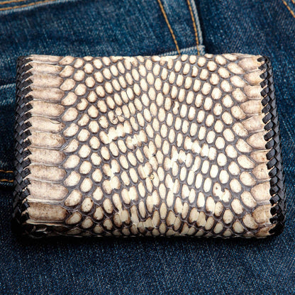 Large natural snake scales in cream and dark brown, framed by braided lacing, viewed straight down.