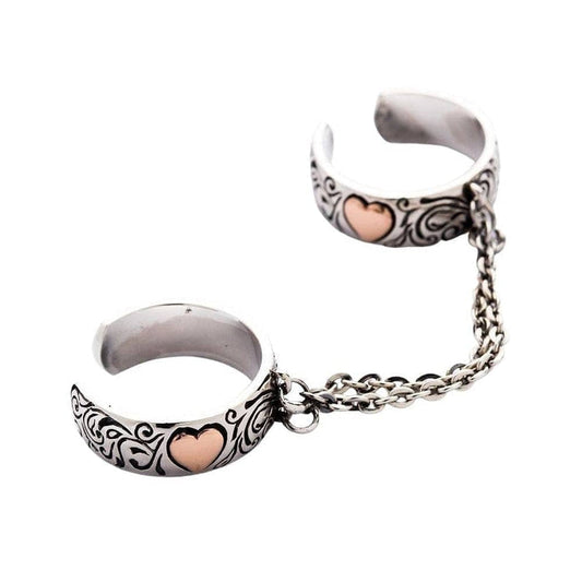 A front view of the adjustable double finger ring with rose gold hearts and gothic engravings.