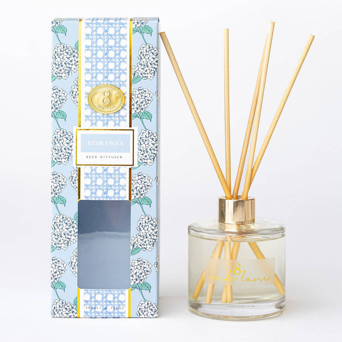 Reed diffuser with floral packaging on a white background