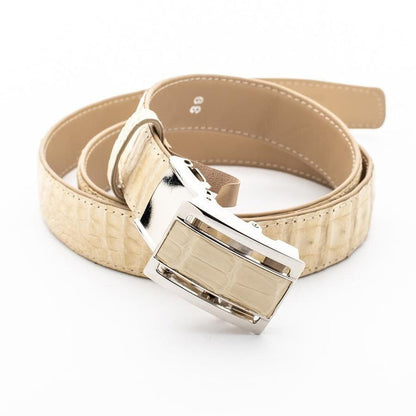 Overhead shot of the coiled ivory crocodile belt, with the silver and leather inlay buckle resting in the foreground.
