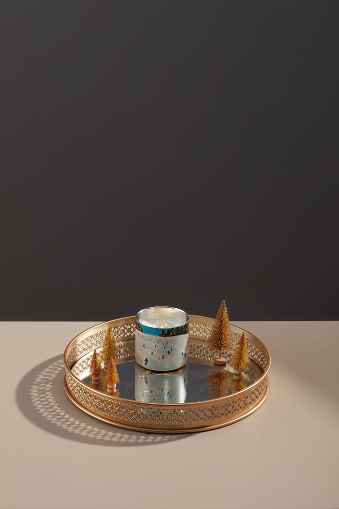 candle with ski pattern in a gold tray with fake trees