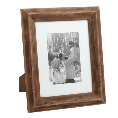 Wooden picture frame with a photo of a couple and child inside on a white background