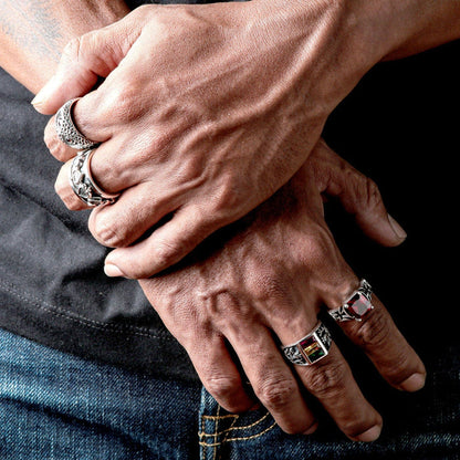 A lifestyle shot of a man wearing the Rasta Lion of Judah ring along with other silver jewelry.