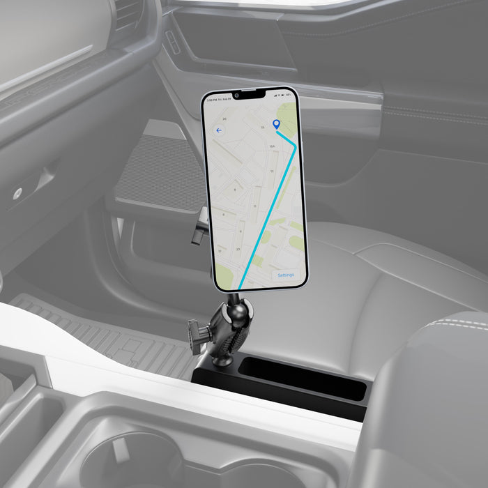 A smartphone is mounted on the Magnetic Holder with Seat Wedge Mount and Dual Shaft Arm – MagSafe Compatible in a car, displaying a GPS navigation route. The MagSafe-compatible magnetic holder is installed near the center console, positioned between the driver’s and passenger’s seats.