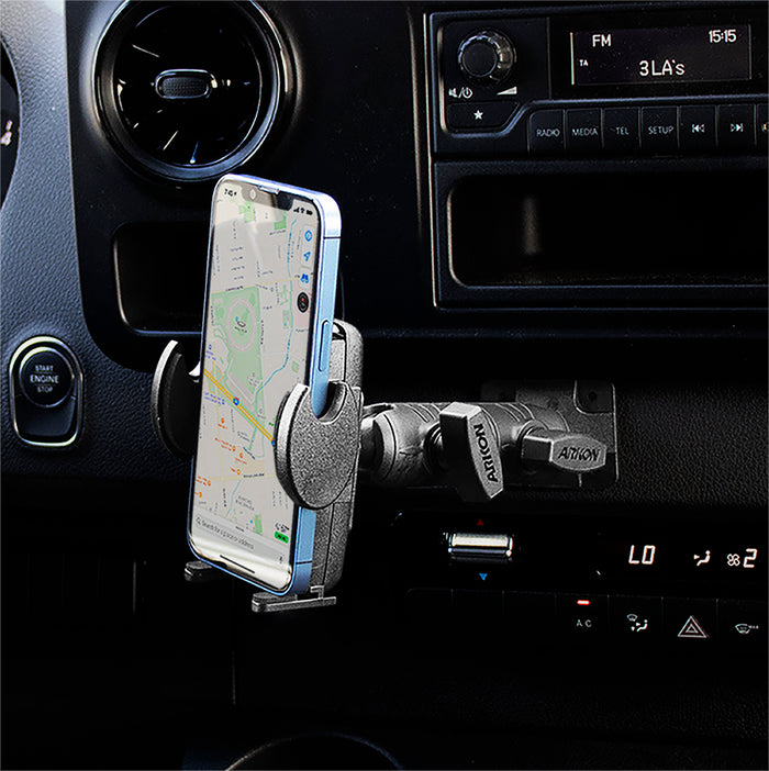 A smartphone displaying a map is mounted on the Mega Grip™ Phone Drill Base Mount with Double Socket Swivel Arm inside a vehicle, with part of the dashboard and controls visible in the background.