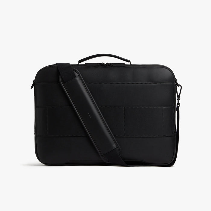 Carbon Black (Vegan Leather) | Back view of Metro Briefcase in Carbon Black with shoulder strap in front