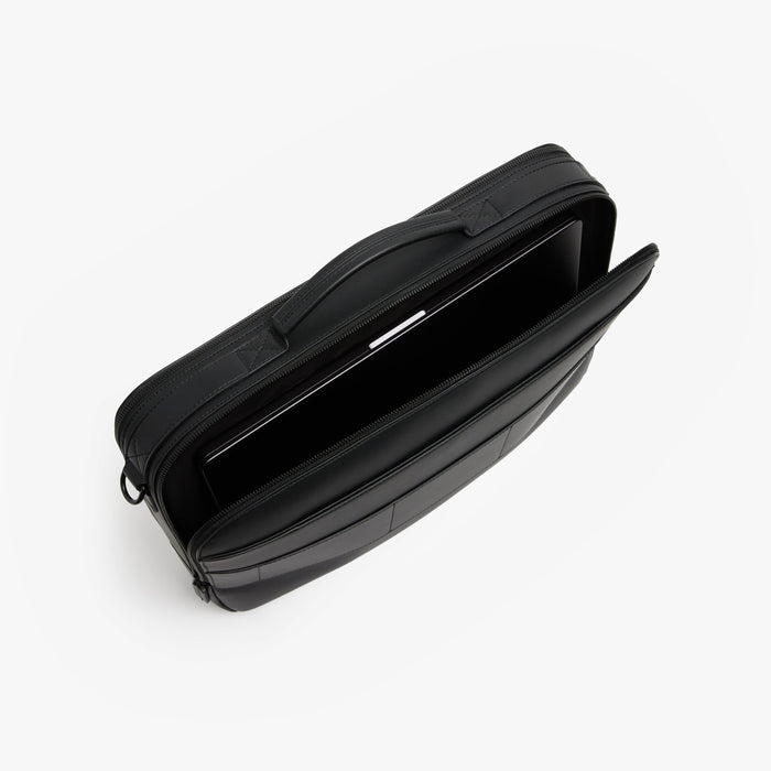 Carbon Black (Vegan Leather) | Angled view of open interior view of Metro Briefcase in Carbon Black showing the padded laptop compartment