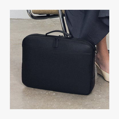 Carbon Black (Vegan Leather) | Female and male model carrying Metro Briefcase in Saddle Tan and Mahogany with shoulder strap