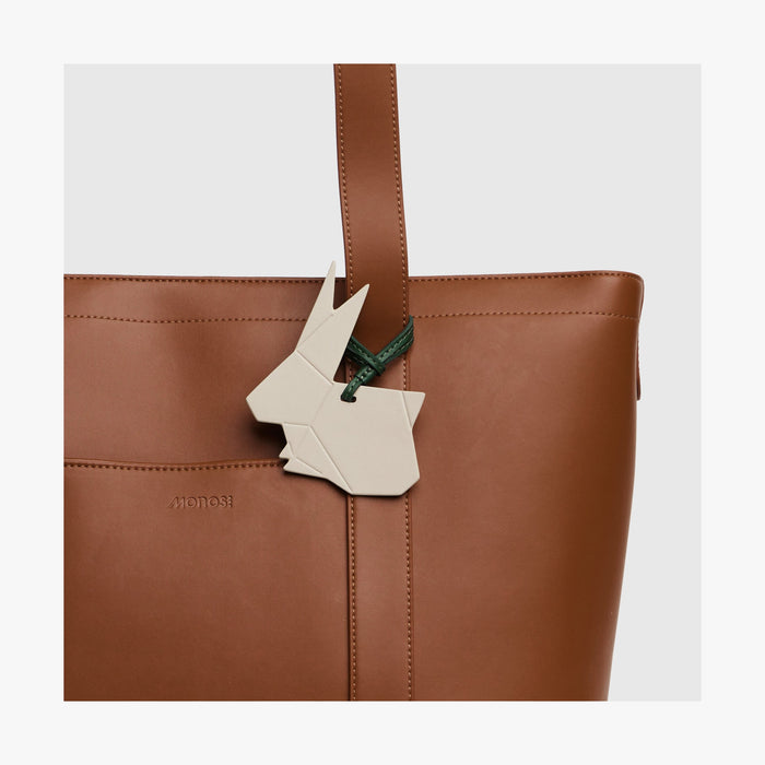 Ivory | Close-up view of the Origami Rabbit Charm attached to a Tote bag