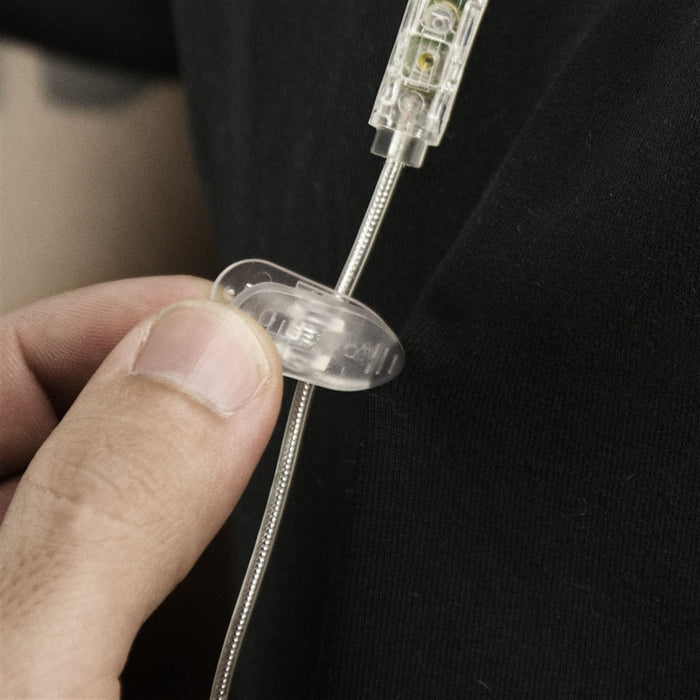 Person holding a Shirt Clip attached to an audio wire for Earphones in Clear