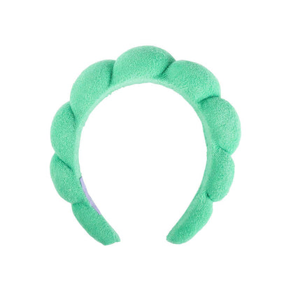 green plush spa headband against a white background